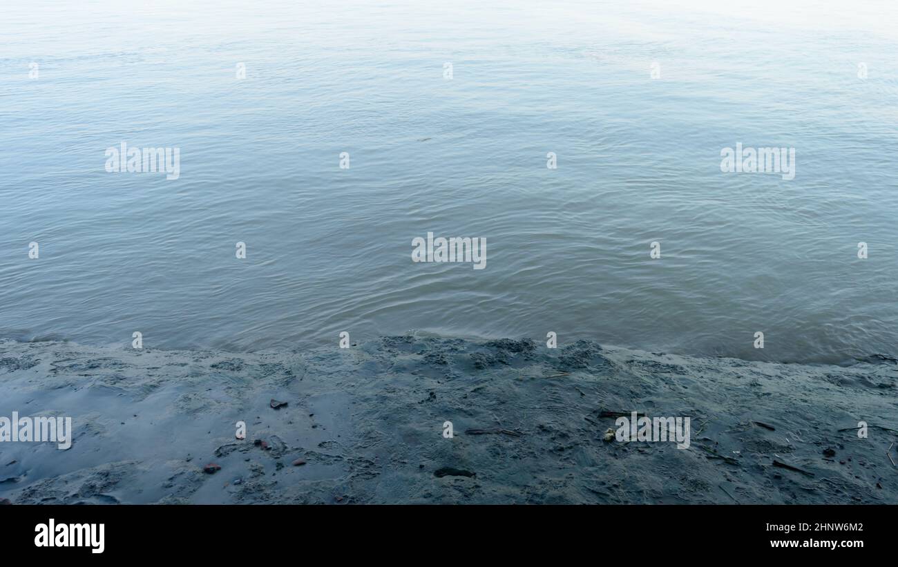 La rivière boueuse est à marée basse près de l'eau des vagues.Sols alluviaux déposés par la rivière.Arrière-plan de la nature.Gros plan. Banque D'Images