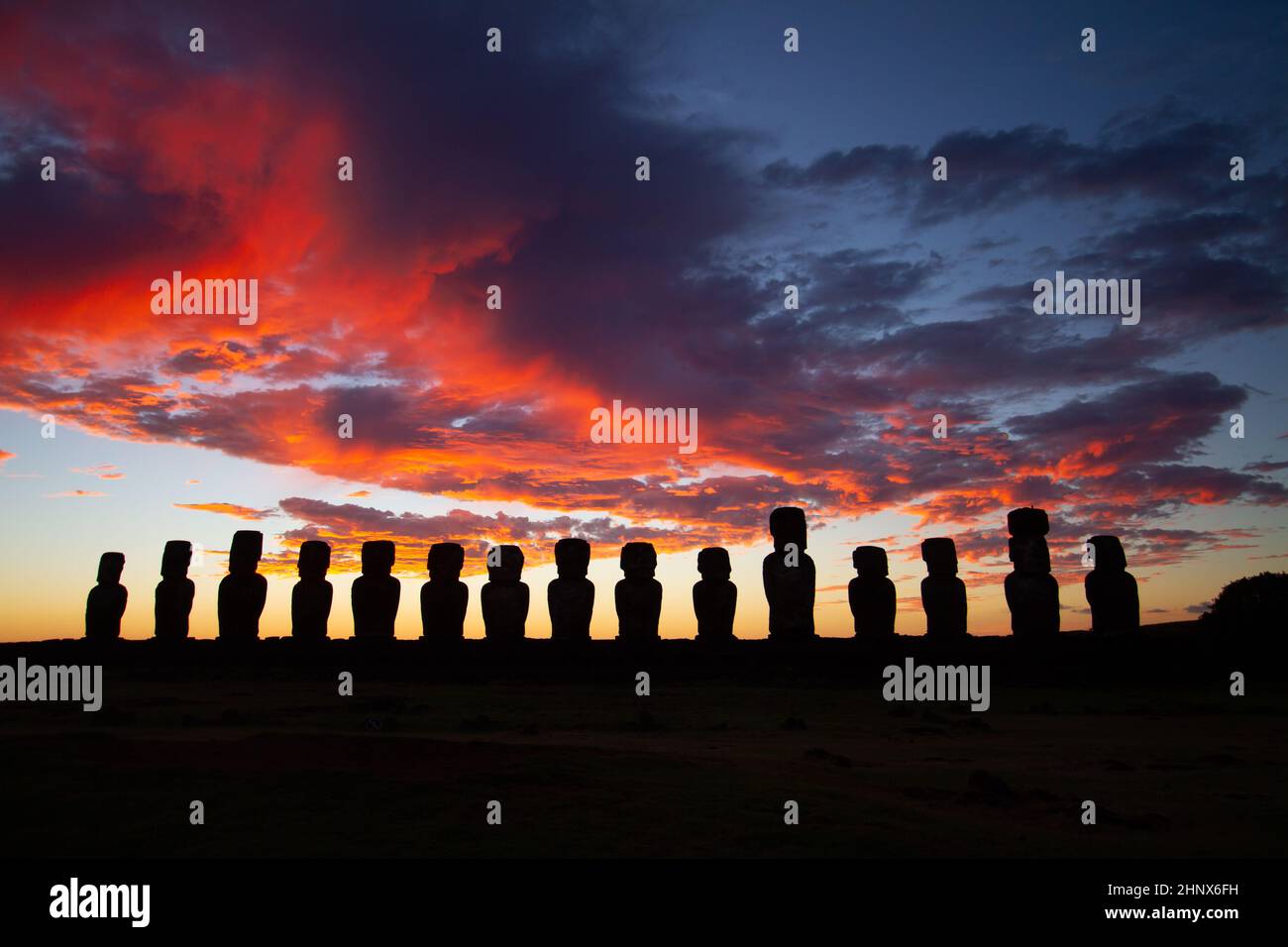 Un lever de soleil spectaculaire et coloré au-dessus des sculptures en pierre de Moai à AHU Tongariki, île de Pâques, au Chili Banque D'Images