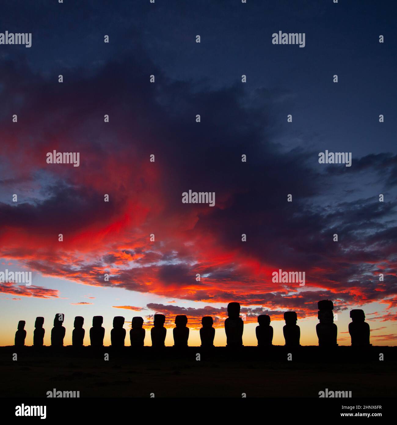 Un lever de soleil spectaculaire et coloré au-dessus des sculptures en pierre de Moai à AHU Tongariki, île de Pâques, au Chili Banque D'Images