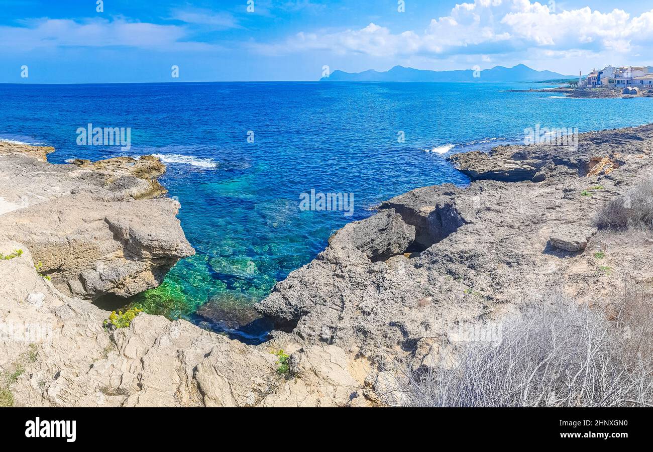 Paysage côtier et de plage rugueux et naturel panorama avec des vagues d'eau turquoise montagnes rochers rochers rochers et pierres dans CAN Picafort sur l'île des Baléares M Banque D'Images