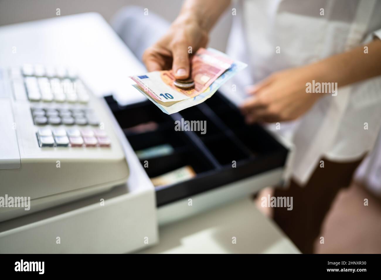 Main du caissier travailler avec la caisse enregistreuse changer la facture d'argent Banque D'Images