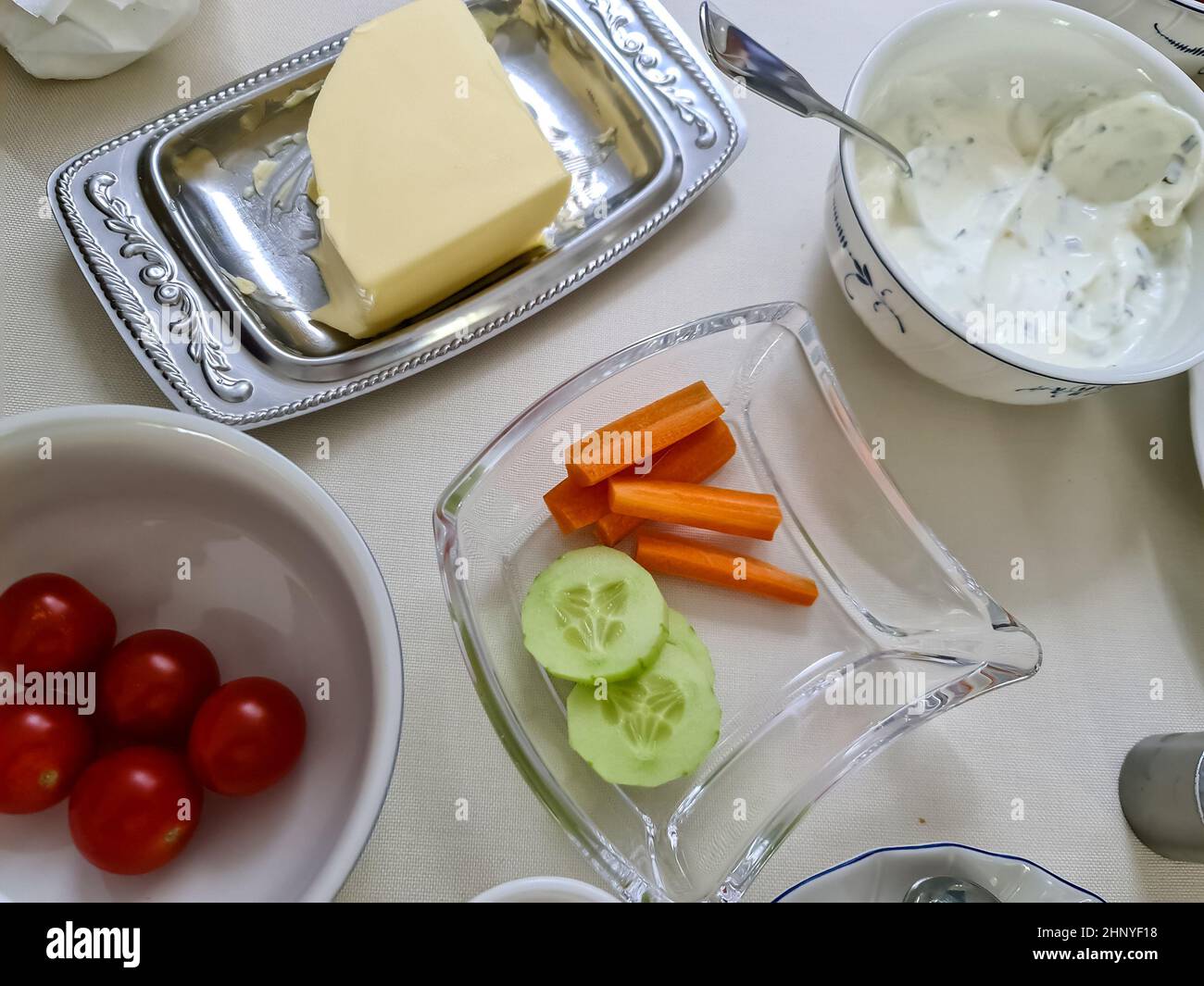 Vue rapprochée sur un petit déjeuner allemand sain avec beurre, tomates et concombres Banque D'Images