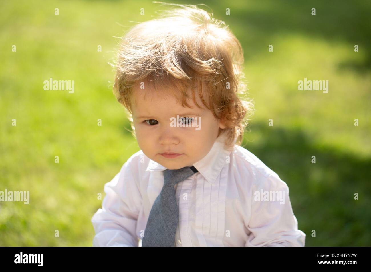 Portrait d'extérieur d'un petit garçon mignon en costume et cravate. Petit  homme d'affaires. Bébé enfant dans l'herbe verte sur la pelouse de  printemps. Petits enfants qui marchent dans le Photo Stock -