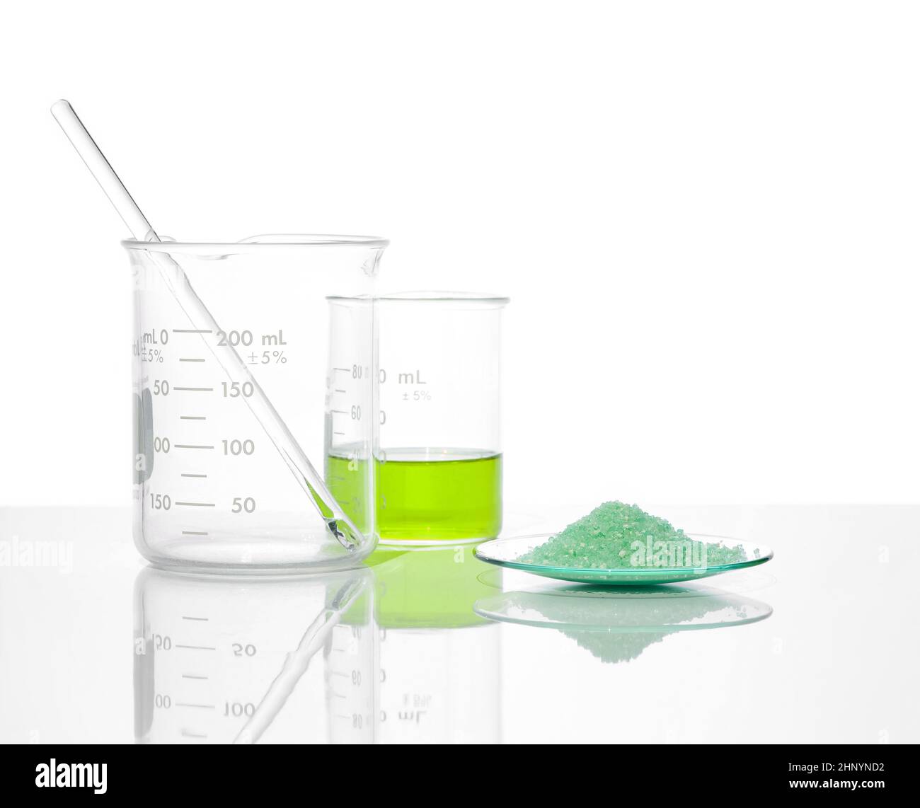 Sulfate ferreux dans le verre de surveillance chimique placer à côté du liquide sulfate de fer (II) dans le bécher.Gros plan sur l'ingrédient chimique sur la table de laboratoire blanche.Côté Banque D'Images