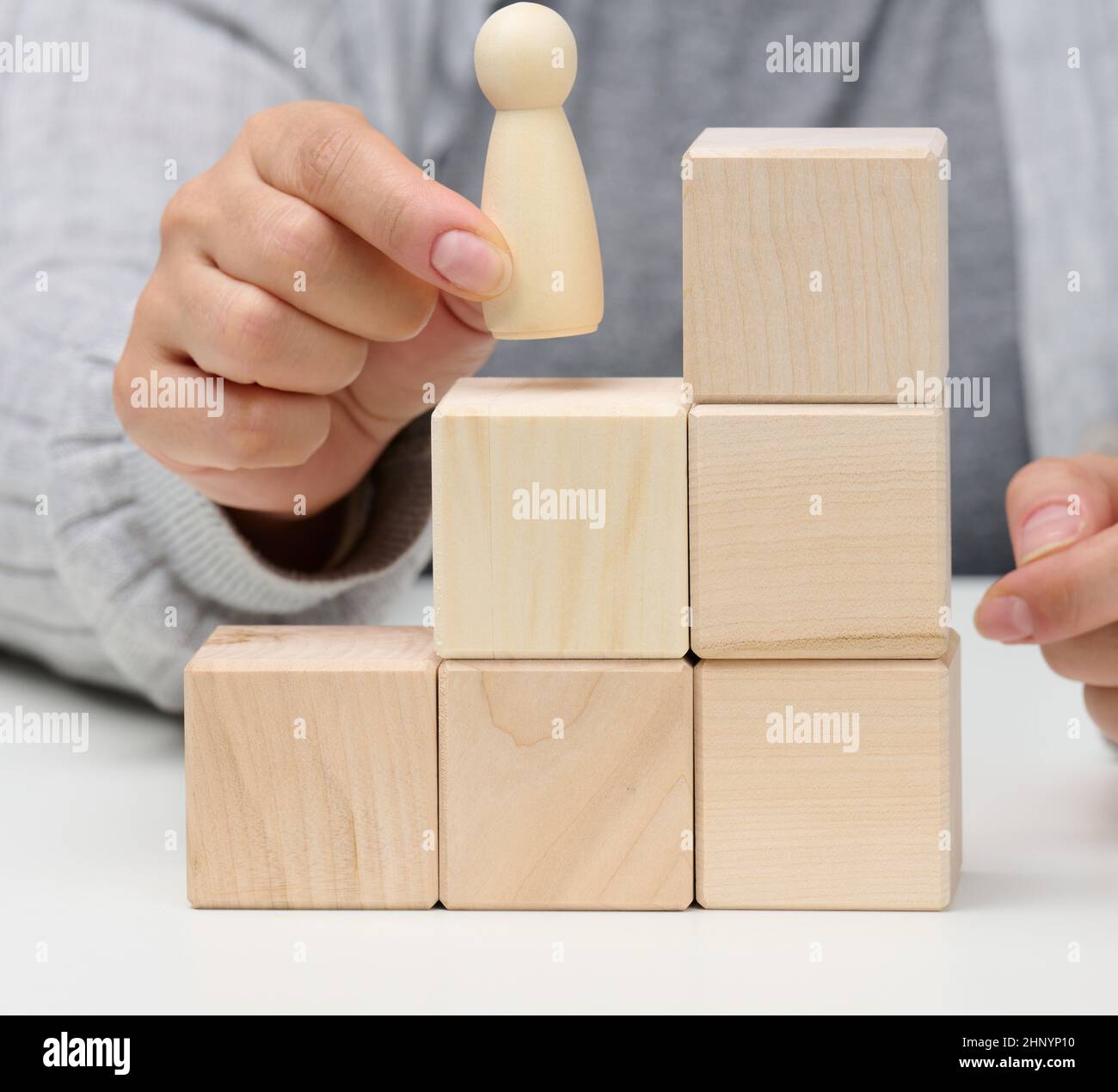 pyramides en cubes de bois et figurines d'hommes sur la table. Le concept de réalisation des objectifs, en passant à l'échelle de carrière. Détection d'esprit unique Banque D'Images