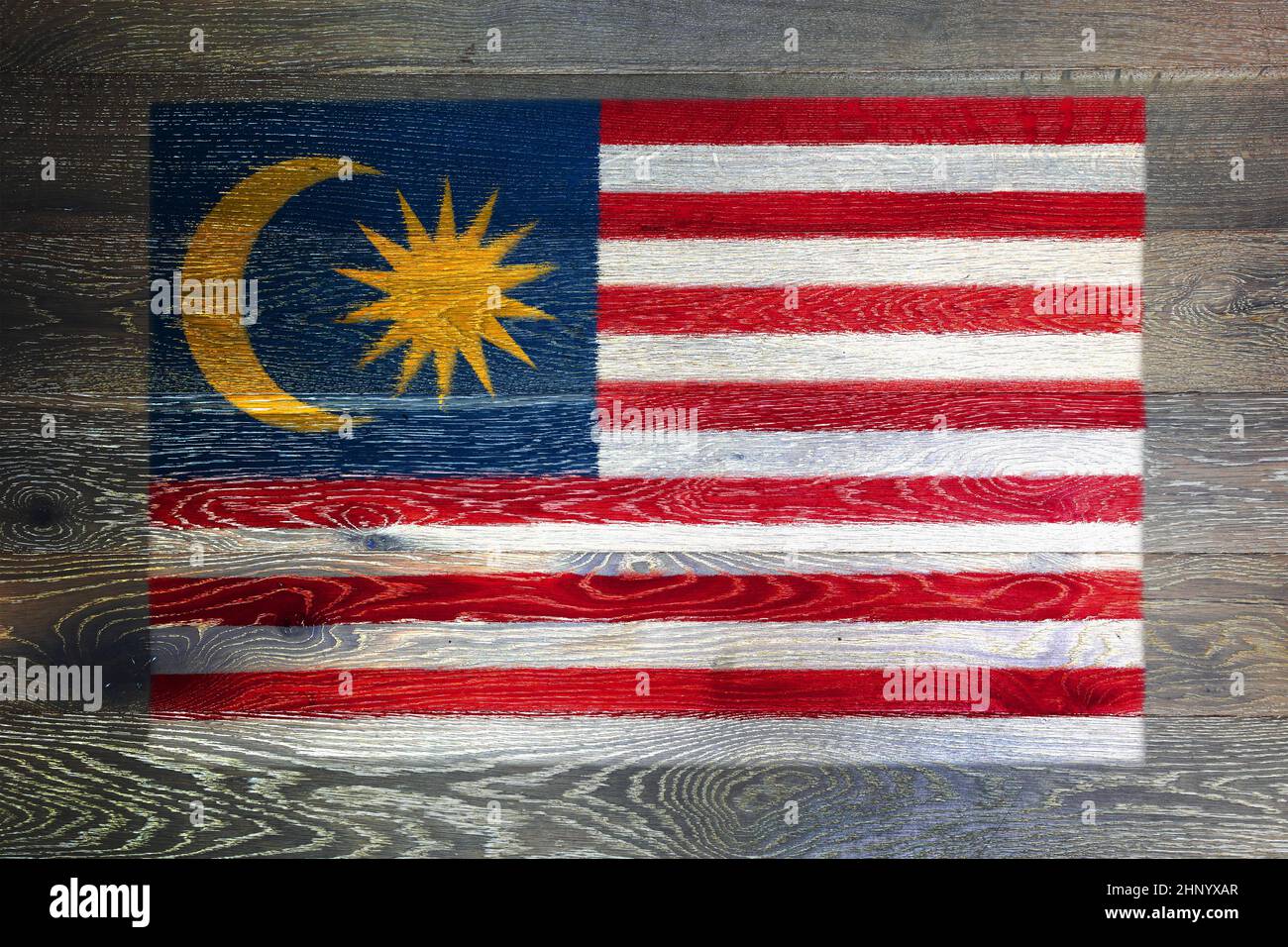 Un drapeau malaisien sur la surface rustique de bois ancien fond lune étoile rouge bandes blanches de gloire malais Banque D'Images