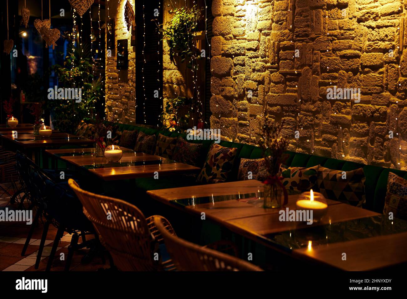 Motif de bougies allumées sur des tables en bois avec reflets de contre-jour Banque D'Images