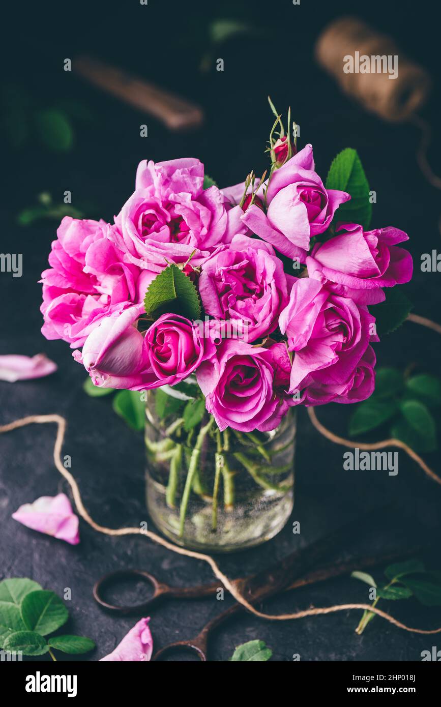 Bouquet de petites roses de jardin en bocal avec eau Banque D'Images