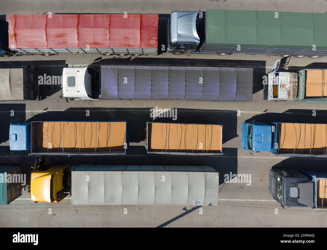 Transport de marchandises. De nombreux camions attendent en file d'attente pour le déchargement dans le port portuaire, vue de dessus d'un quadricoptère sur les camions chargés de grain. Concep Banque D'Images