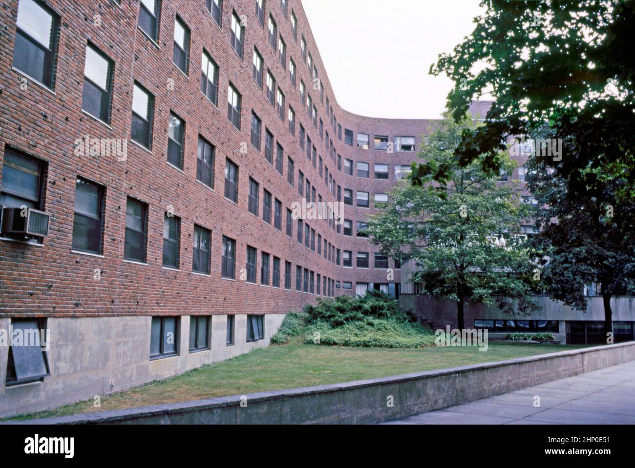 Une vue de 1982 des courbes distinctives de Baker House, au Massachusetts Institute of Technology, Cambridge, Massachusetts, Etats-Unis. Lvar Aalto a conçu le dortoir de Baker House en 1946 alors qu'il était professeur au Massachusetts Institute of Technology (MIT). Hugo Alvar Henrik (Ivar) Aalto (1898–1976) est un architecte et designer finlandais. Le dortoir était l'un de ses bâtiments aux Etats-Unis. Le bloc de dortoir est revêtu de briques de la Nouvelle-Angleterre, avec sa texture rugueuse, pour recouvrir les courbes de la serpentine du bâtiment. Cette image est tirée d'une ancienne transparence de couleur amateur – une photographie vintage 1980s. Banque D'Images