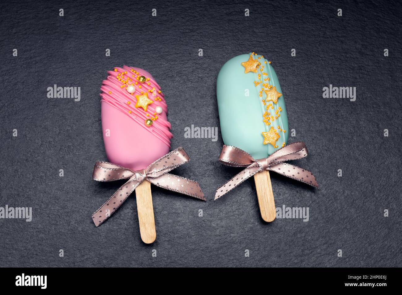 deux cake pops décorés glaces avec des noeuds sur fond noir. Vue de dessus. Banque D'Images