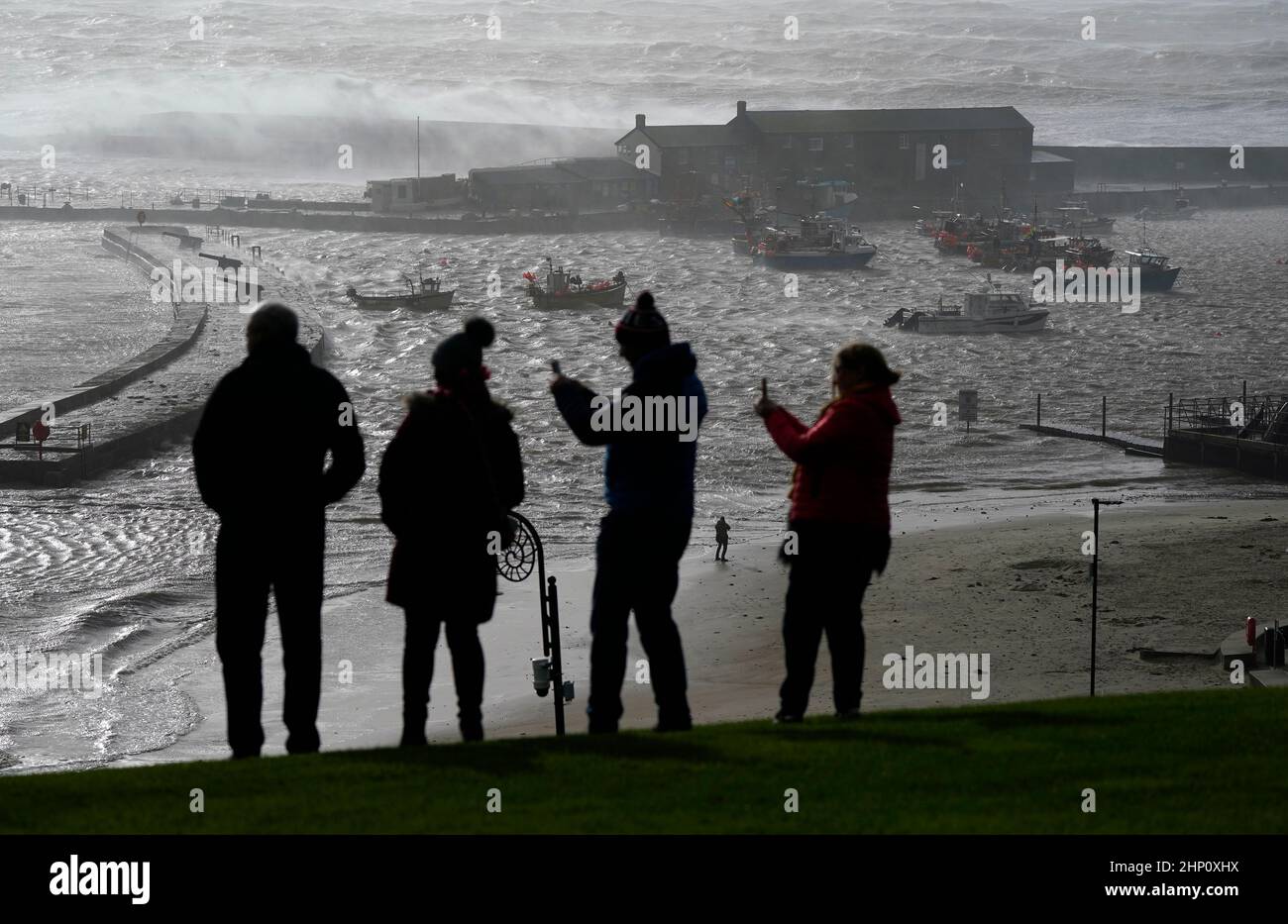 Les gens regardent vers la mer comme les vagues crash contre la Cobb