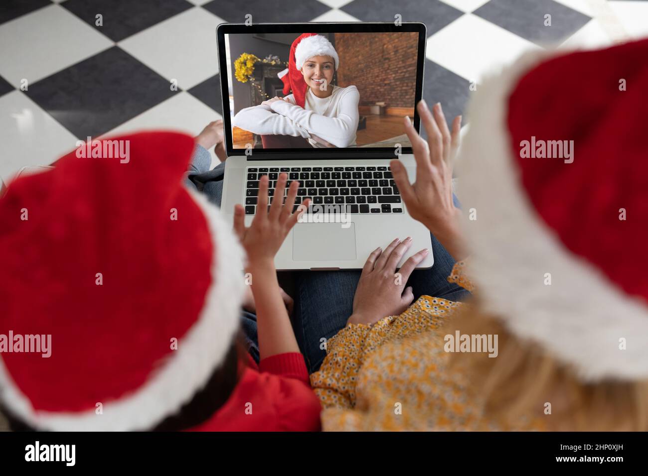 Femme caucasienne avec sa fille à la maison à Noël, en utilisant un ordinateur portable, chat vidéo avec un Banque D'Images