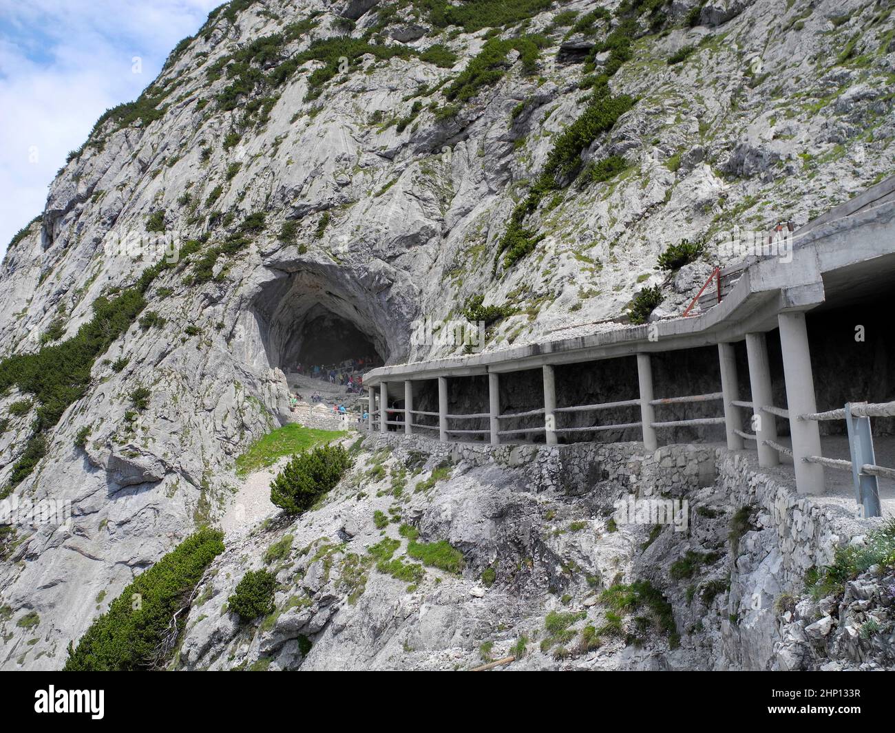 L'Autriche, les gens à l'entrée et à l'abri le long de la roche font face à Eisriesenwelt - la plus grande grotte de glace du monde Banque D'Images