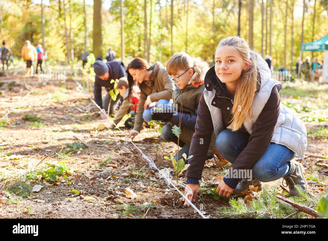 Groupe de volontaires et d'enfants plantant des arbres dans la forêt pour la durabilité et la protection du climat Banque D'Images