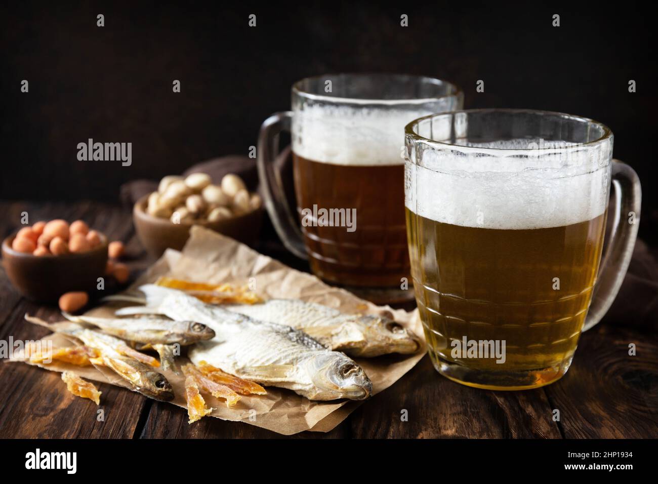 Alcool de bière lager et pinte de stout, bière artisanale. Deux verres de bière avec mousse et en-cas sur un fond rustique en bois. Traditionnel allemand Wha Banque D'Images