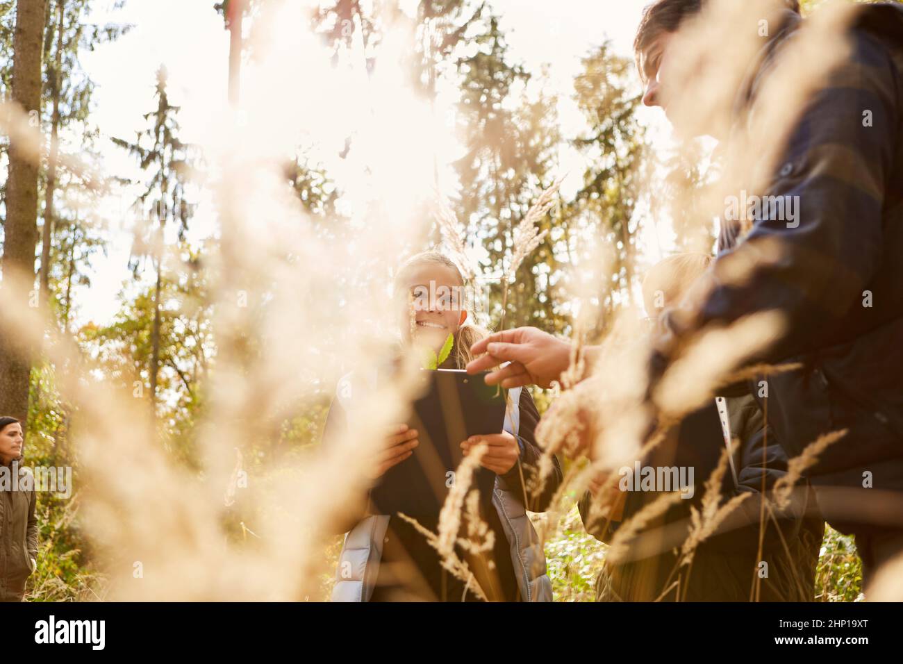 Enfant et forestier avec des herbes et des plantes en botanique ou leçons d'histoire naturelle dans la forêt Banque D'Images