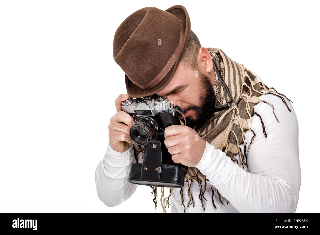 Jeune homme élégant photographe avec appareil photo rétro prend des photos sur fond blanc Banque D'Images