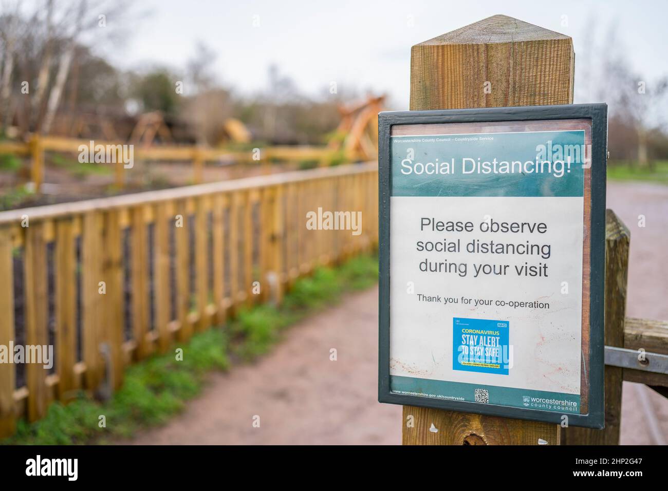 Gros plan d'un panneau social de distance fixé à la porte dans un parc public de campagne britannique. Banque D'Images