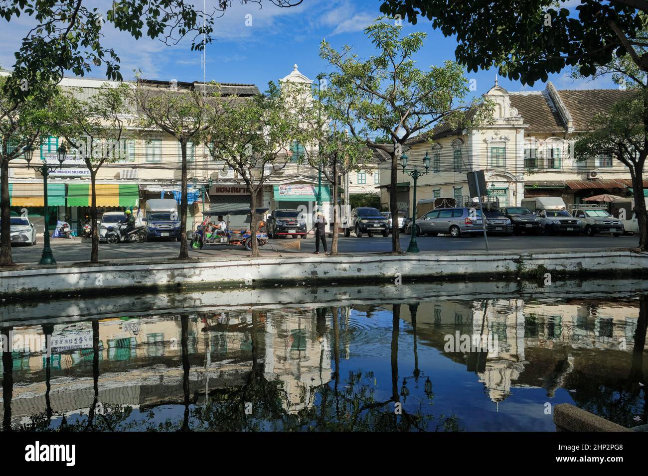 Vieux entrepôts pittoresques et magasins bordant la route d'Atsadang le long de Klong (canal) Lod dans le quartier de la vieille ville de Bangkok, en Thaïlande, se reflète dans l'eau Banque D'Images