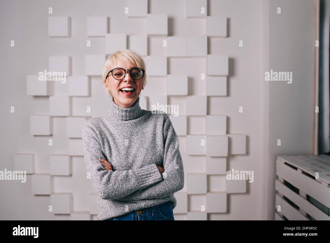 Une femme joyeuse riant dans une pièce lumineuse Banque D'Images