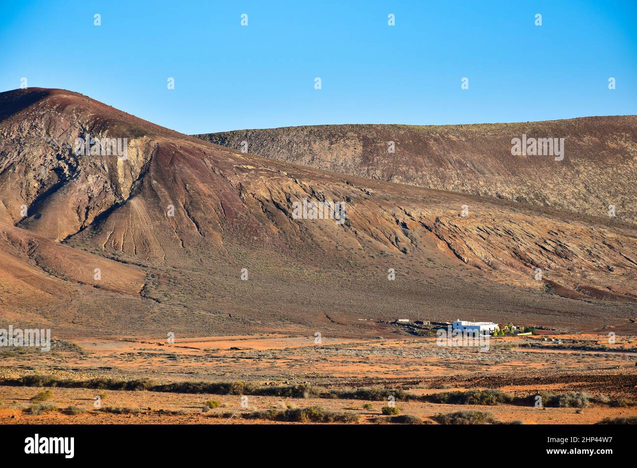 Magnifique paysage volcanique avec une maison blanche en face.Près de Costa Teguise, Lanzarote, Iles Canaries, Espagne.Image prise sur le terrain public. Banque D'Images