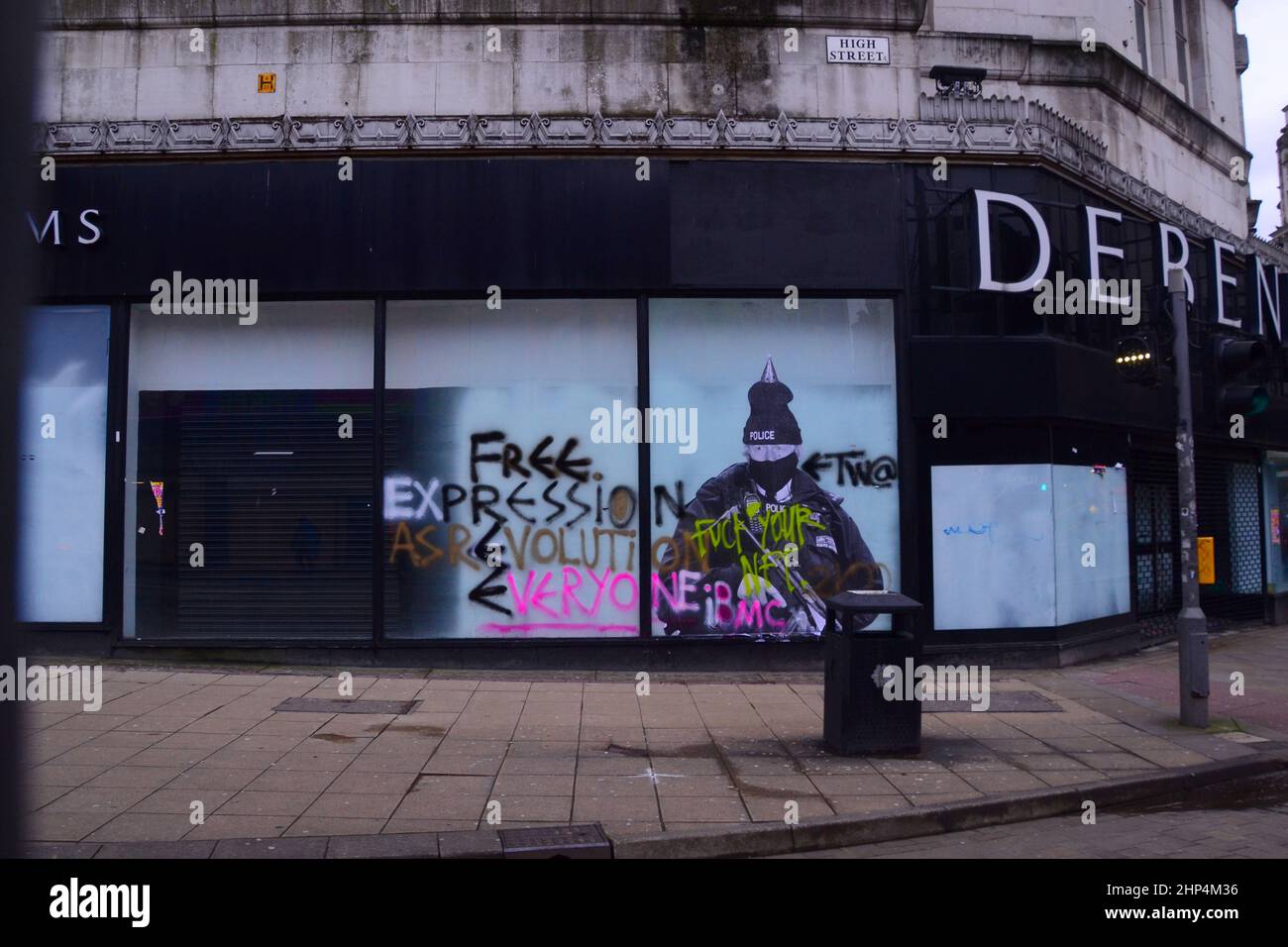 Manchester, Royaume-Uni, 18th février 2022. Une fresque humoristique présentant le Premier ministre britannique Boris Johnson sur l'ancien magasin Debenhams dans le centre de Manchester, au Royaume-Uni, a été vandalisée deux fois jusqu'à présent avec des graffitis. Réalisée par 'Foka Wolf', une artiste de rue, la fresque a la tête de Boris Johnson, portant un chapeau de fête, sur l'image d'un policier armé. Il y a une enquête policière sur les parties au 10 Downing Street pendant les écluses de Covid-19. L'artiste a mentionné ce qu'il considère comme des « deux normes » du gouvernement. Crédit : Terry Waller/Alay Live News Banque D'Images