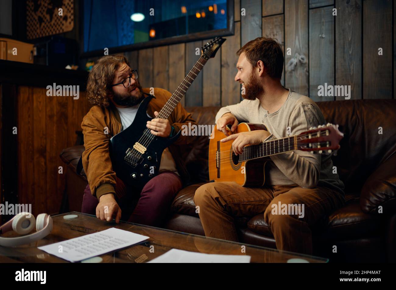 Instructeur enseignant homme jouer de la guitare au studio à la maison. Professeur et étudiant parlant. Classe de maître de la musique Banque D'Images