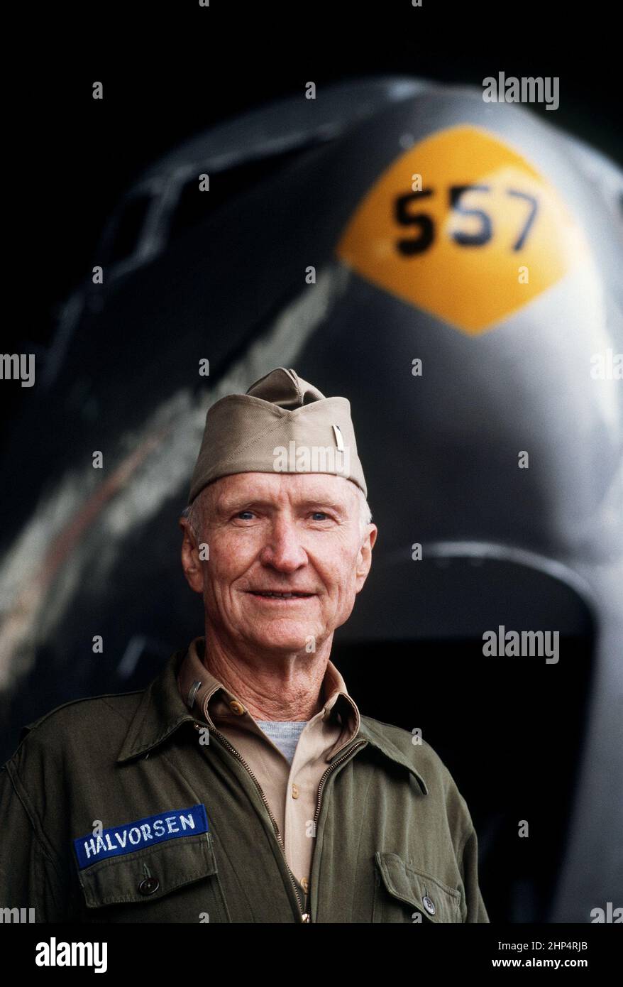 Le col Gail S. Halvorsen, à la retraite, se dresse dans un hangar à l'aéroport central de Tempelhof, devant un avion C-54 Skymaster. Halvorsen, pilote pendant le pont aérien de Berlin, est devenu connu sous le nom de « Rosinen (Raisin) Bomber » pour sa pratique consistant à faire tomber des bonbons aux enfants qui étaient alignés pour observer l'atterrissage d'un avion à Tempelhof, Berlin-Ouest, 6/23/1988. Banque D'Images
