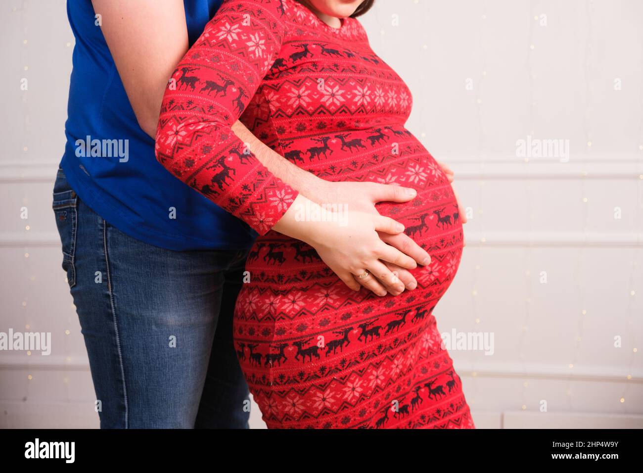 Le mari épouse enceinte et les pates sur le ventre, grossesse pour Noël