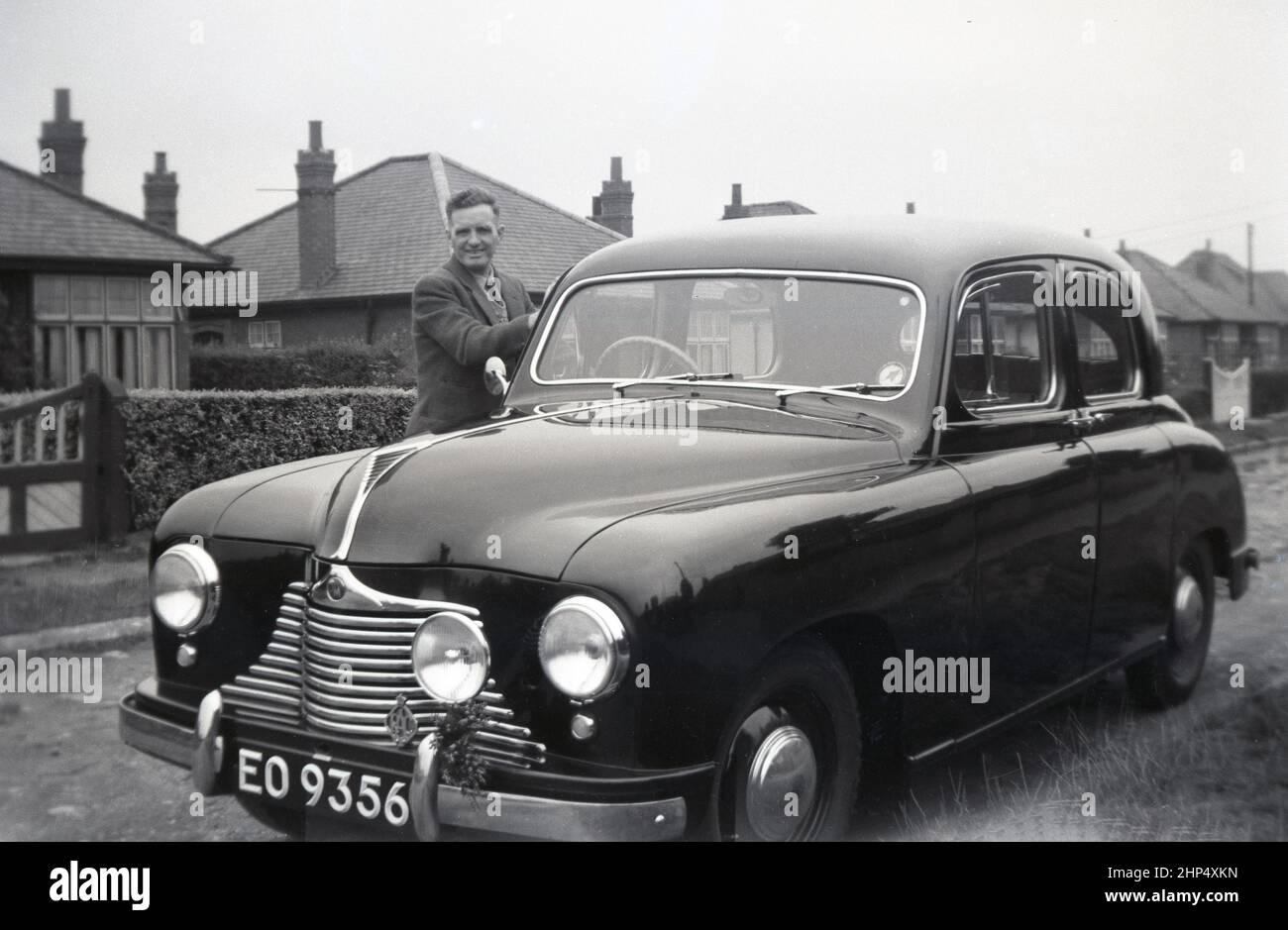 1940s, historique, à l'extérieur d'une route surburban, un homme debout à côté de sa nouvelle voiture, un chanteur SM1500, Angleterre, Royaume-Uni. Petite berline familiale de 4 portes produite entre 1948 et 1956, la SM1500 a été fabriquée par Singer Motors, une compagnie automobile britannique fondée en 1874 à Coventry, en Angleterre, par George Singer. D'origine fabricant de bicyclettes, en 1901, l'entreprise a commencé à fabriquer des voitures à moteur. Banque D'Images