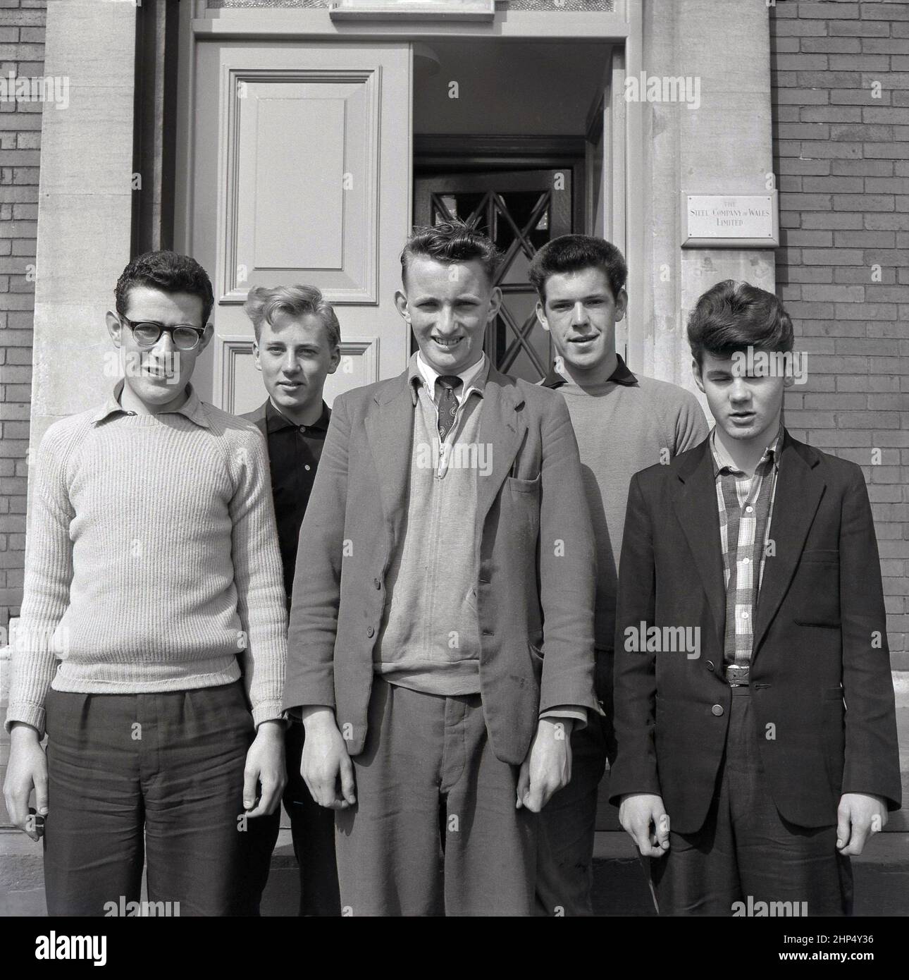 1950s, jeunes apprentis d'ingénierie hommes historiques dans une usine d'acier située à l'extérieur de l'entrée pour leur photo, Steel Company of Wales, Abbey Works, Port Talbot, pays de Galles, Royaume-Uni. Banque D'Images