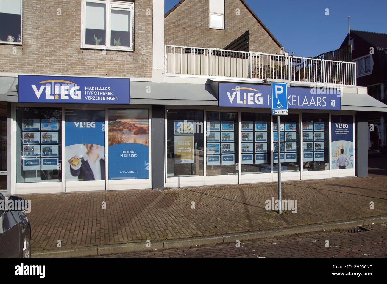 Agence immobilière néerlandaise 'Vlieg' dans le village de Bergen. Derrière les fenêtres des annonces de maisons à vendre. Avant du magasin. Pays-Bas, février Banque D'Images