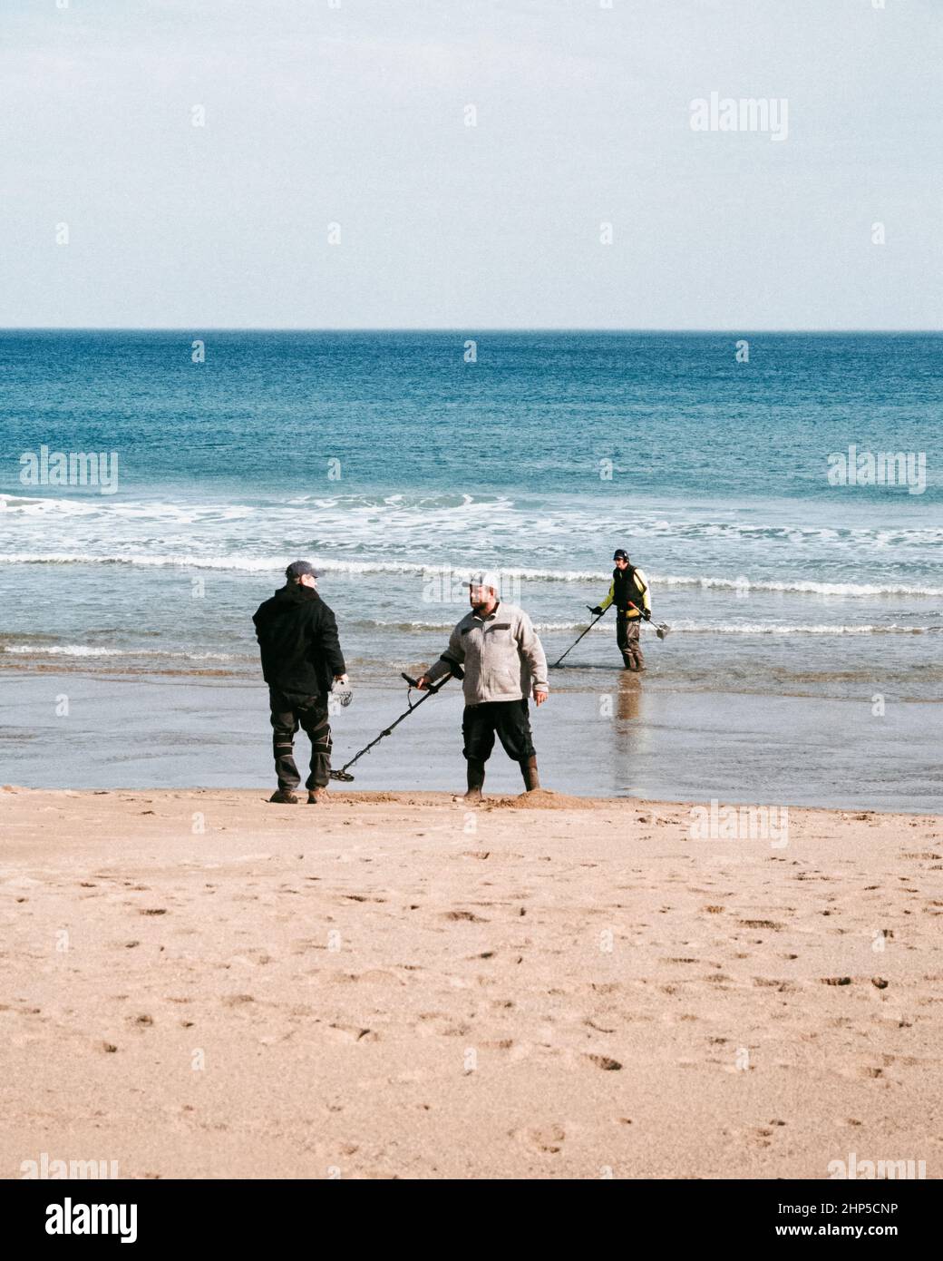 Les prospecteurs de jour modernes balaient la rive avec des détecteurs de métaux lors d'un après-midi d'hiver chaud et lumineux à Salisbury Beach, NHG Banque D'Images