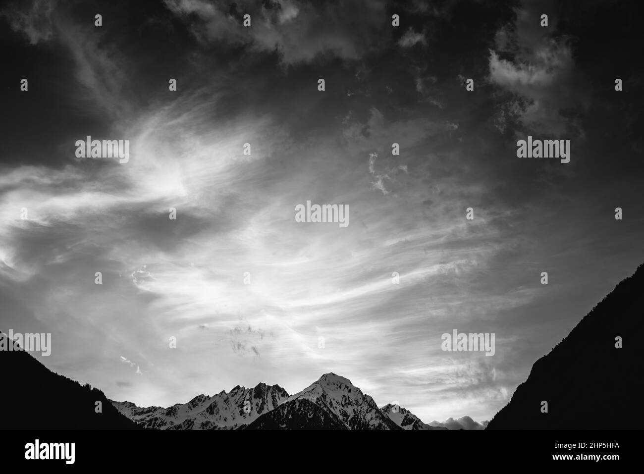 Nuages au coucher du soleil sur une montagne enneigée en Italie, noir et blanc. Monochrome Banque D'Images