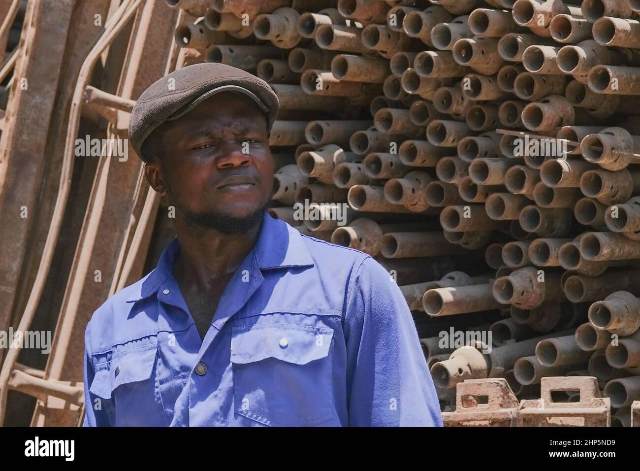 Attention sélective face à l'homme noir africain ouvrier portant l'uniforme bleu, travaillant pour l'entrepôt d'approvisionnement de ferraille pour le recyclage. Abu Dhabi, Émirats arabes Unis Banque D'Images