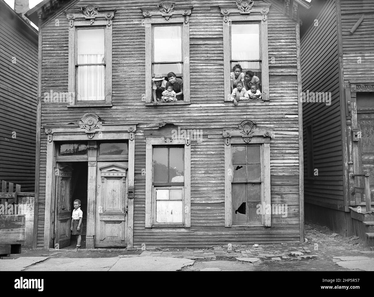 Groupe de personnes regardant par les fenêtres dans Rundown House, Chicago, Illinois, USA, Russell Lee, U.S. Office of War information/États-Unis Administration de la sécurité agricole, avril 1941 Banque D'Images