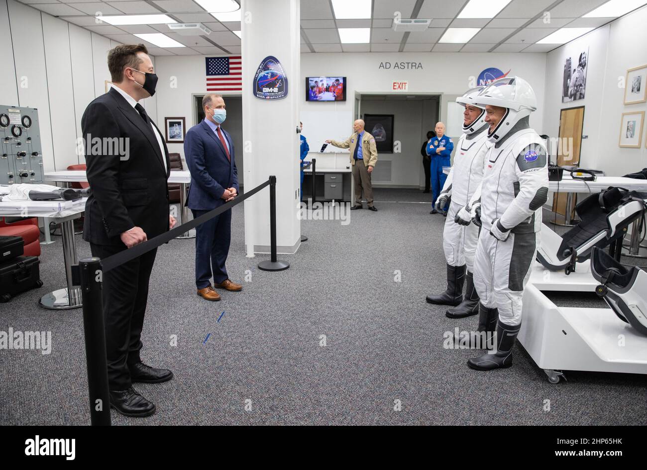 Derrière la corde, Elon Musk, PDG de SpaceX, et Jim Bridenstine, administrateur de la NASA, saluent les astronautes de la NASA Robert Behnken (à gauche) et Douglas Hurley dans les quartiers des astronautes du bâtiment Neil A. Armstrong Operations and Checkout du Kennedy Space Center de la NASA en Floride, avant la mission SpaceX Demo-2 de l'agence. Banque D'Images