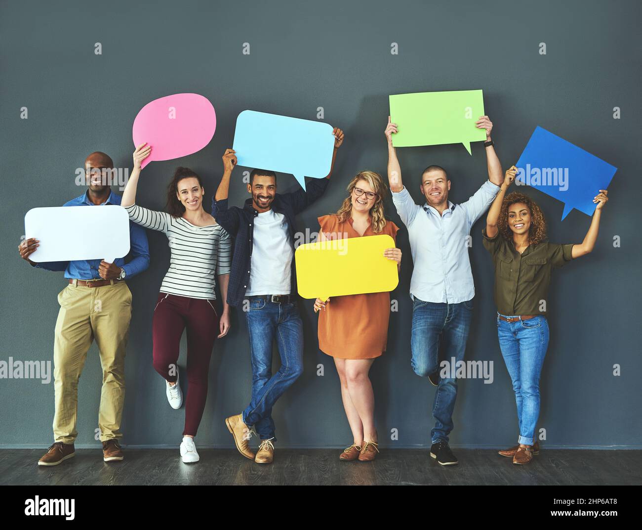 Nous avons tous une opinion qui compte. Photo en studio d'un groupe diversifié de personnes tenant des bulles de parole sur un fond gris. Banque D'Images
