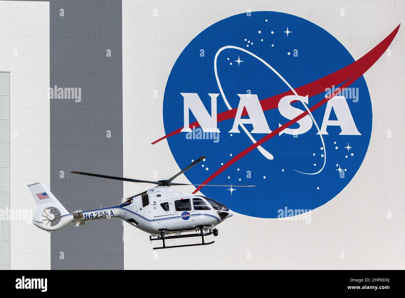 Devant le bâtiment d'assemblage de véhicules du Kennedy Space Center de la NASA, un hélicoptère utilisé pour les opérations de sécurité au port spatial de Floride effectue un vol vers. 2020 Banque D'Images