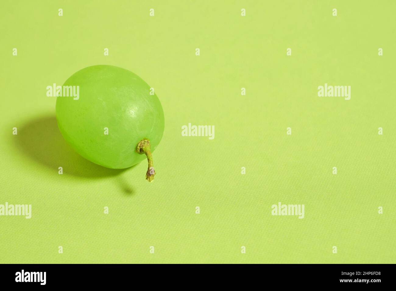 Une baie de raisins verts en gros plan sur un fond coloré Banque D'Images