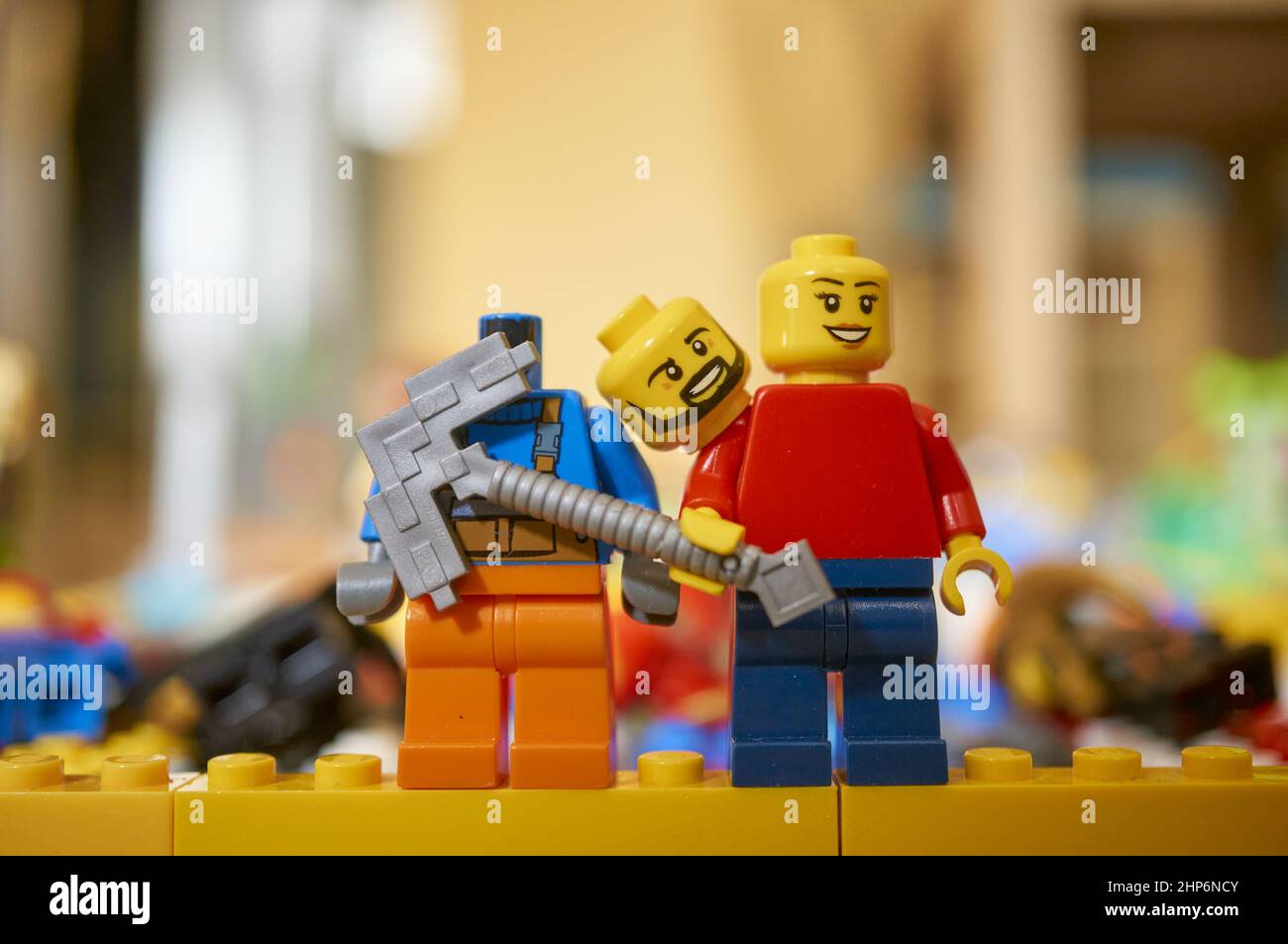 Figurine en peluche de la marque LEGO avec une hache debout à côté d'un  homme sans tête sur un fond flou Photo Stock - Alamy
