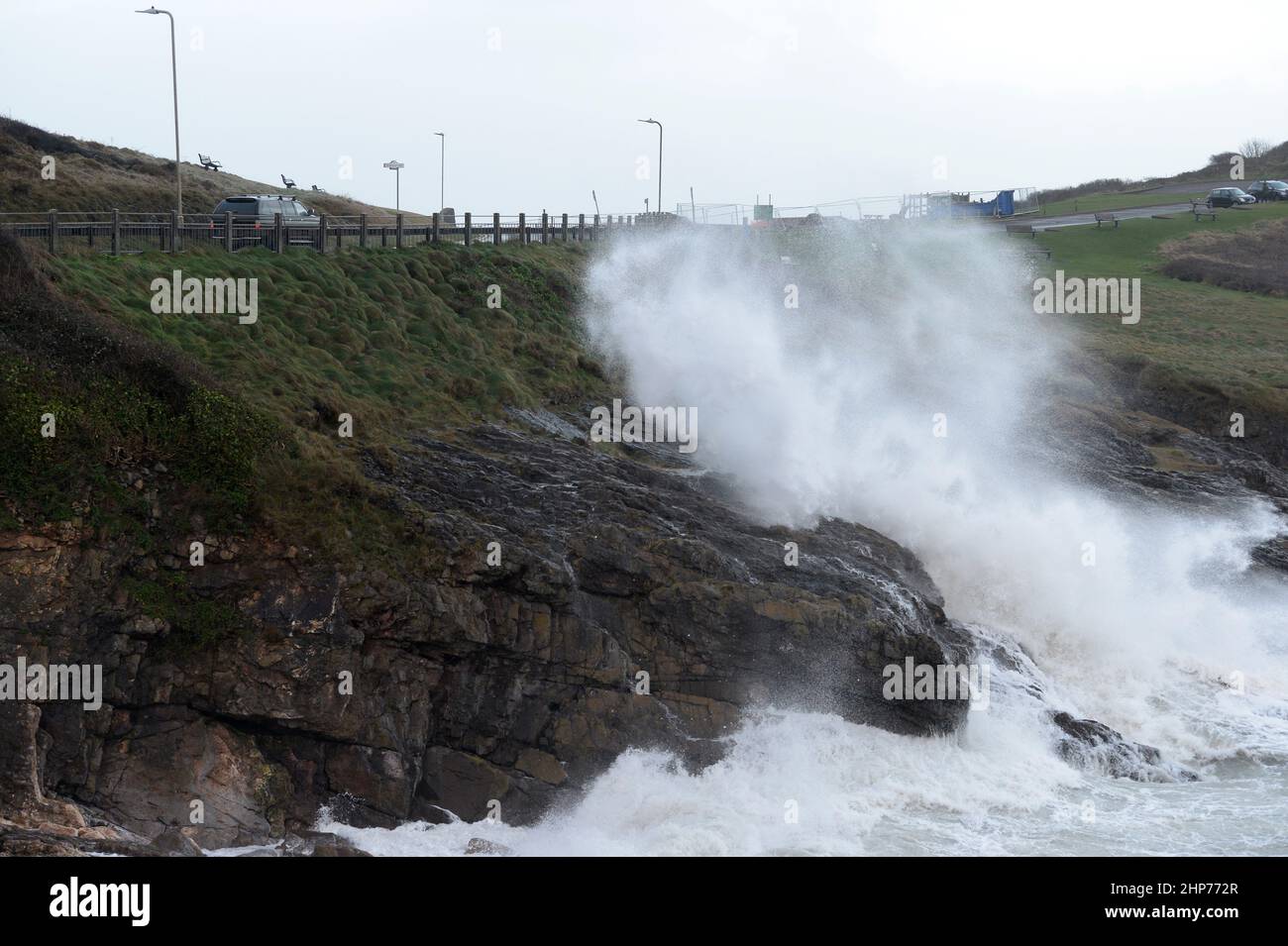 Les Mumbles .18th février 2022 les vagues couvrent la route, une voiture qui passe attend un passage sûr à Limeslade, Mumbles, Swansea, pays de Galles, Royaume-Uni. Crédit Phil Holden/ Banque D'Images