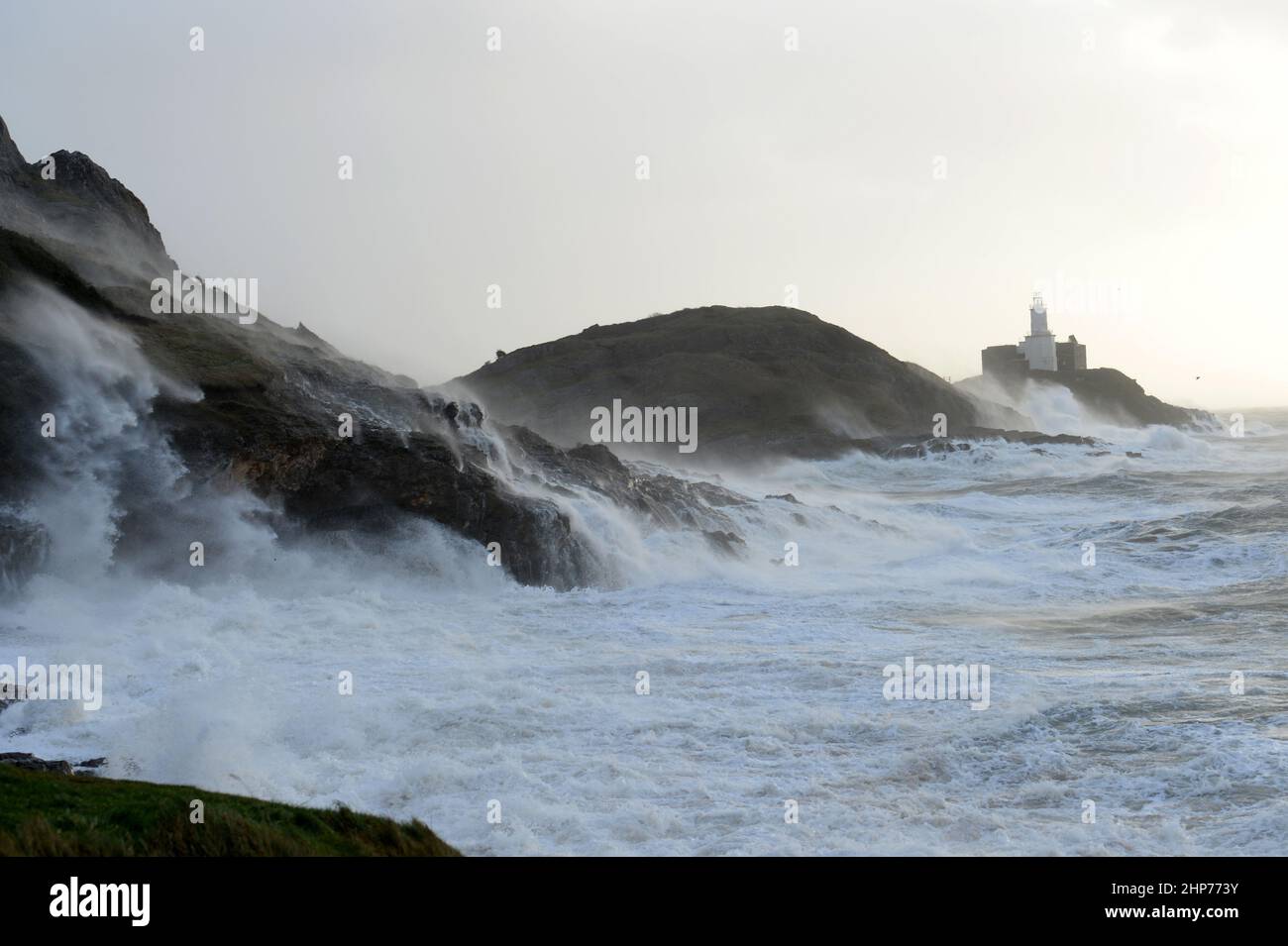 Storm Eunice aux Mumbles. Swansea, pays de Galles, Royaume-Uni. Les vagues se brisent au-dessus du phare et du promontoire, tandis que les vents de 90mph soufflent et que les vagues s'engloutissent dans les falaises Banque D'Images