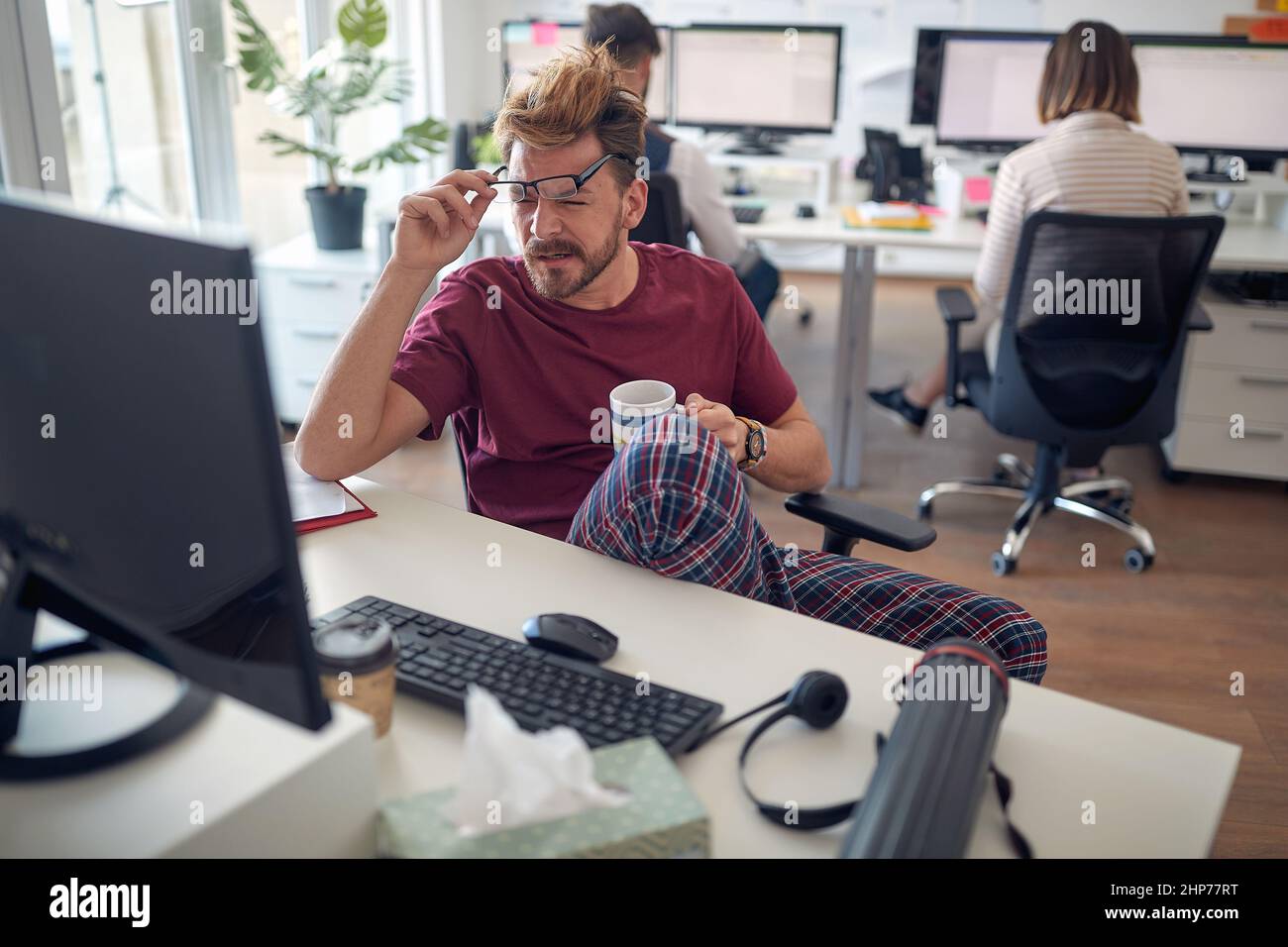 Un jeune homme est détendu tout en travaillant dans une atmosphère agréable au bureau. Employés, travail, bureau Banque D'Images