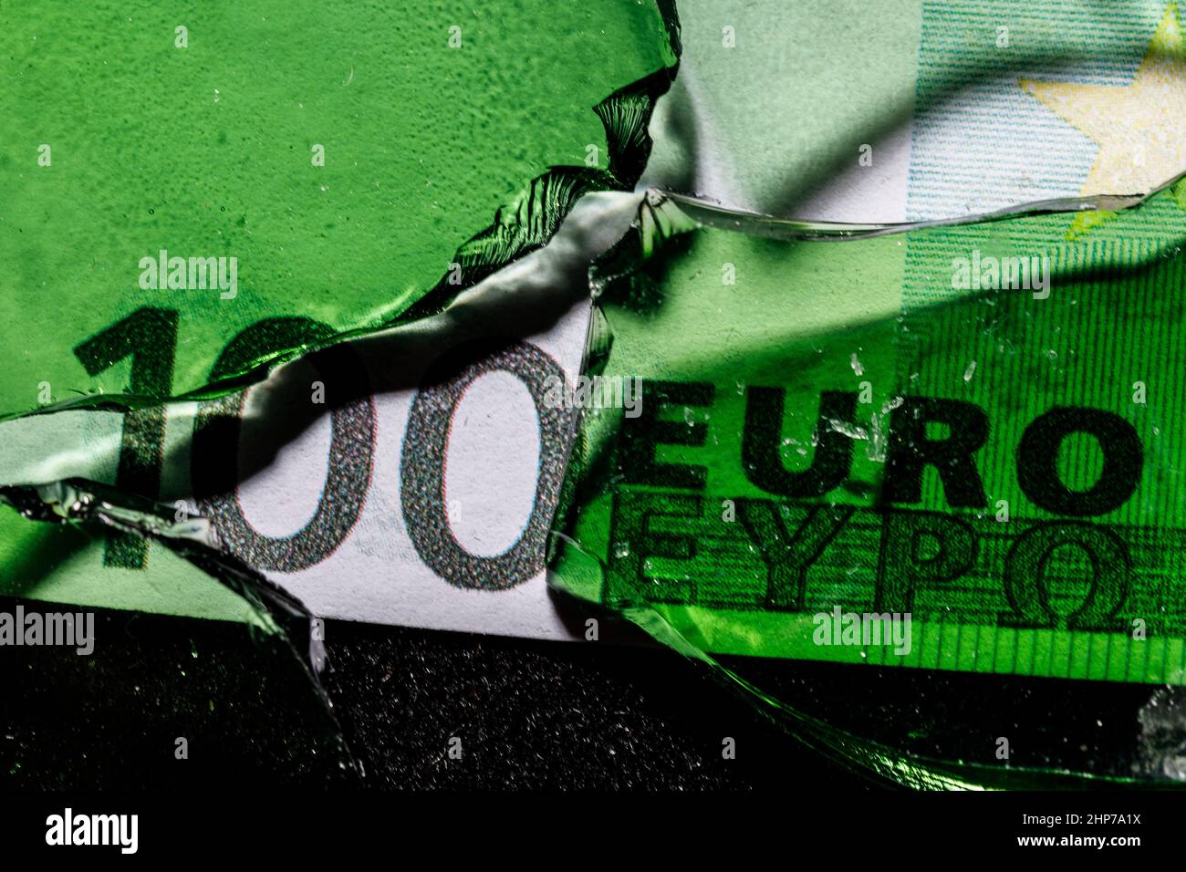 une centaine de billets en euros avec verre brisé vert. concept de crise financière. Photo de haute qualité Banque D'Images