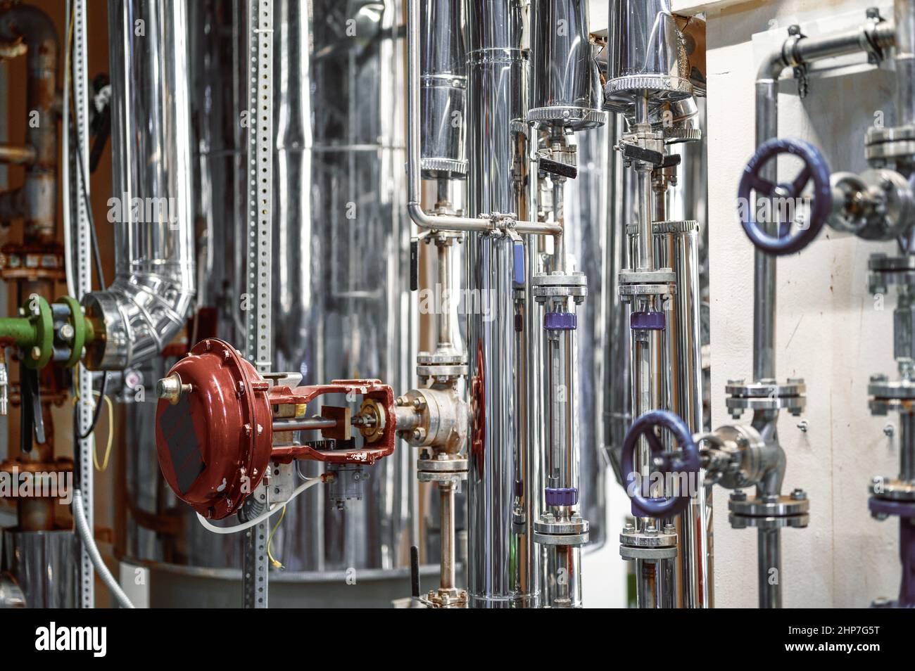 Tuyaux métalliques fins avec petites vannes bleues et brides à l'usine Banque D'Images