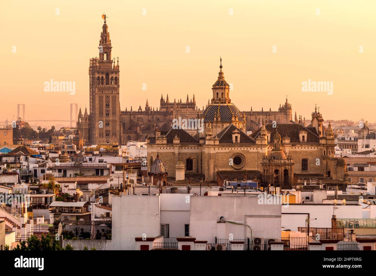Coucher de soleil Séville - Tour la Giralda et toit de la cathédrale de Séville qui s'élève derrière le dôme de l'église du Divin Sauveur. Séville, Espagne. Banque D'Images