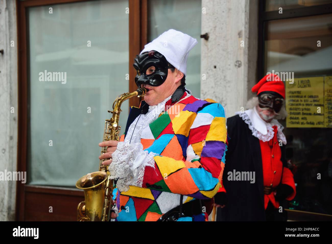 Carnaval de Venise 2022. Dans un jour brumeux, après deux ans d'arrêt dû à Covid, le carnaval de Venise tente de recommencer, avec quelques difficultés. Un samedi brumeux, les touristes se promo sur la place San Marco et quelques masques colorés posent pour des photographes curieux. Banque D'Images