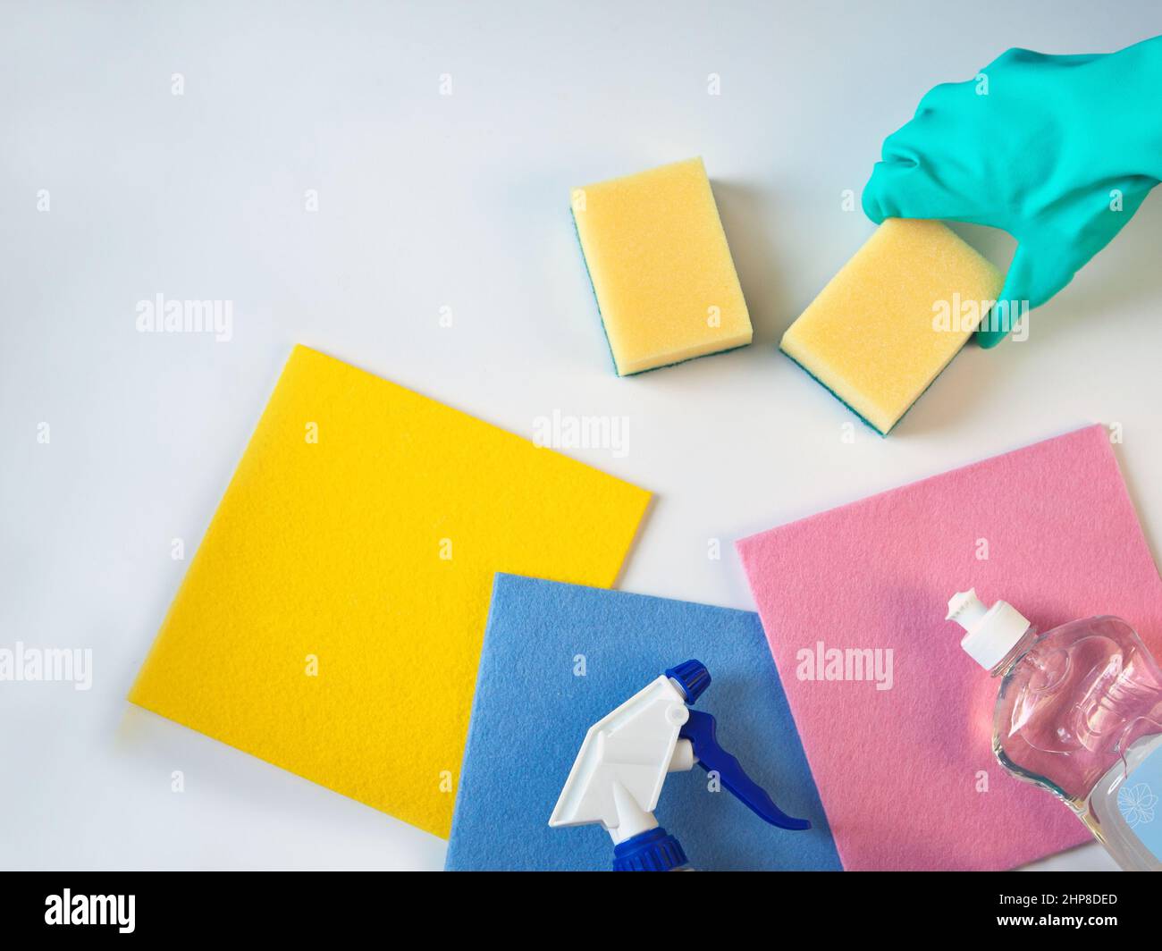 main dans des glowes. Produits chimiques ménagers en bouteilles, chiffon et éponge pour le nettoyage. Produits de lavage de la vaisselle. Banque D'Images
